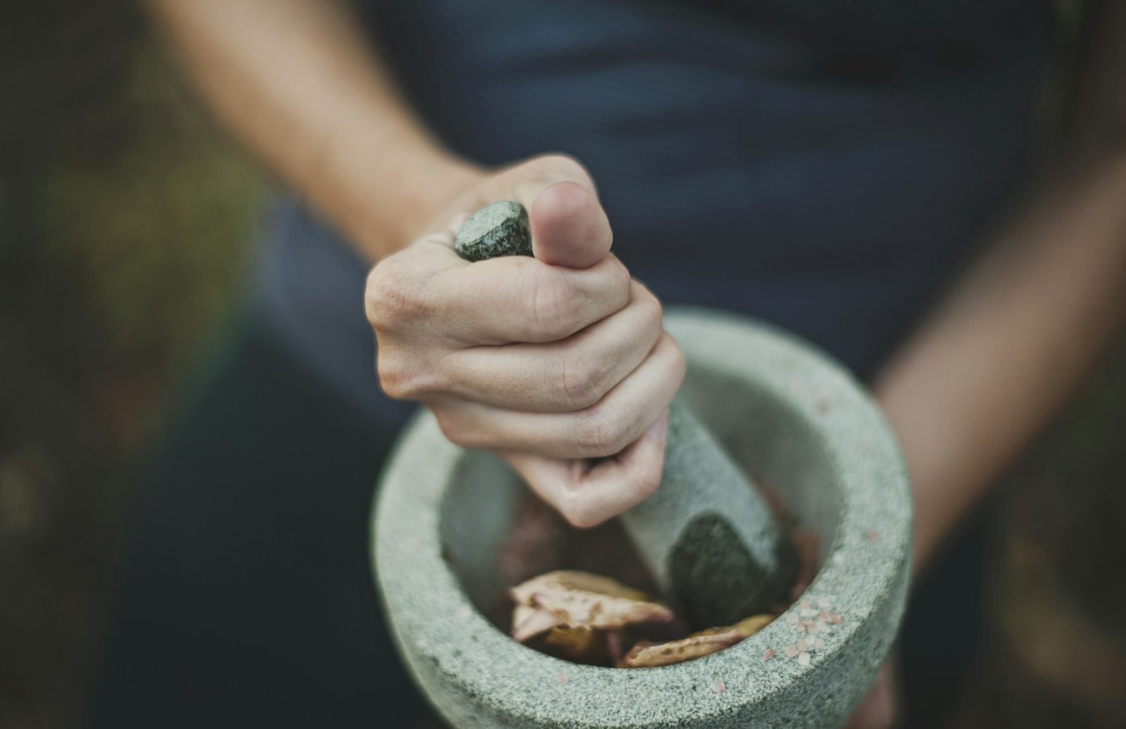 Person grinding spices with a mortar and pestle