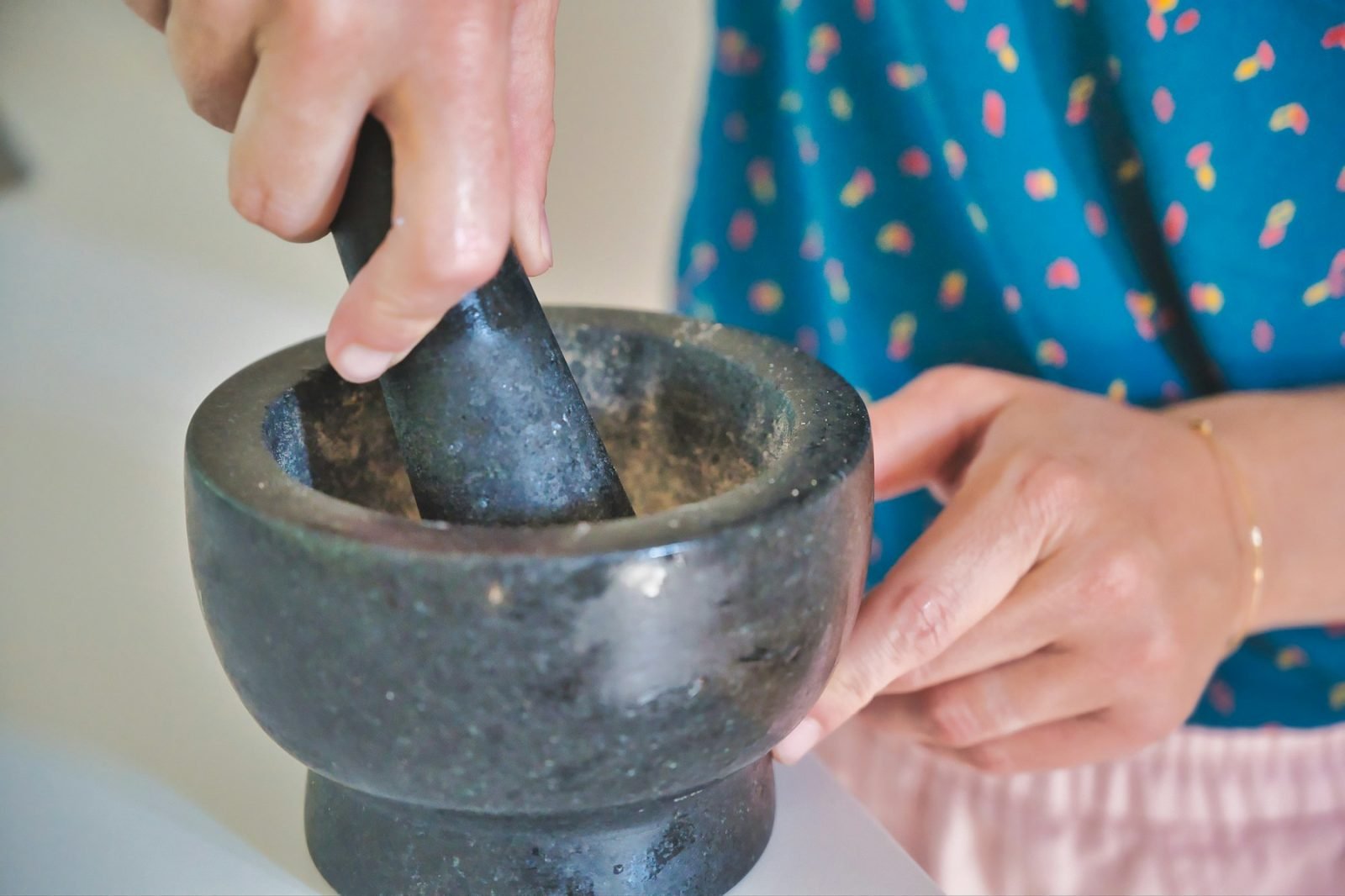 Person holding a grey mortar and pestle